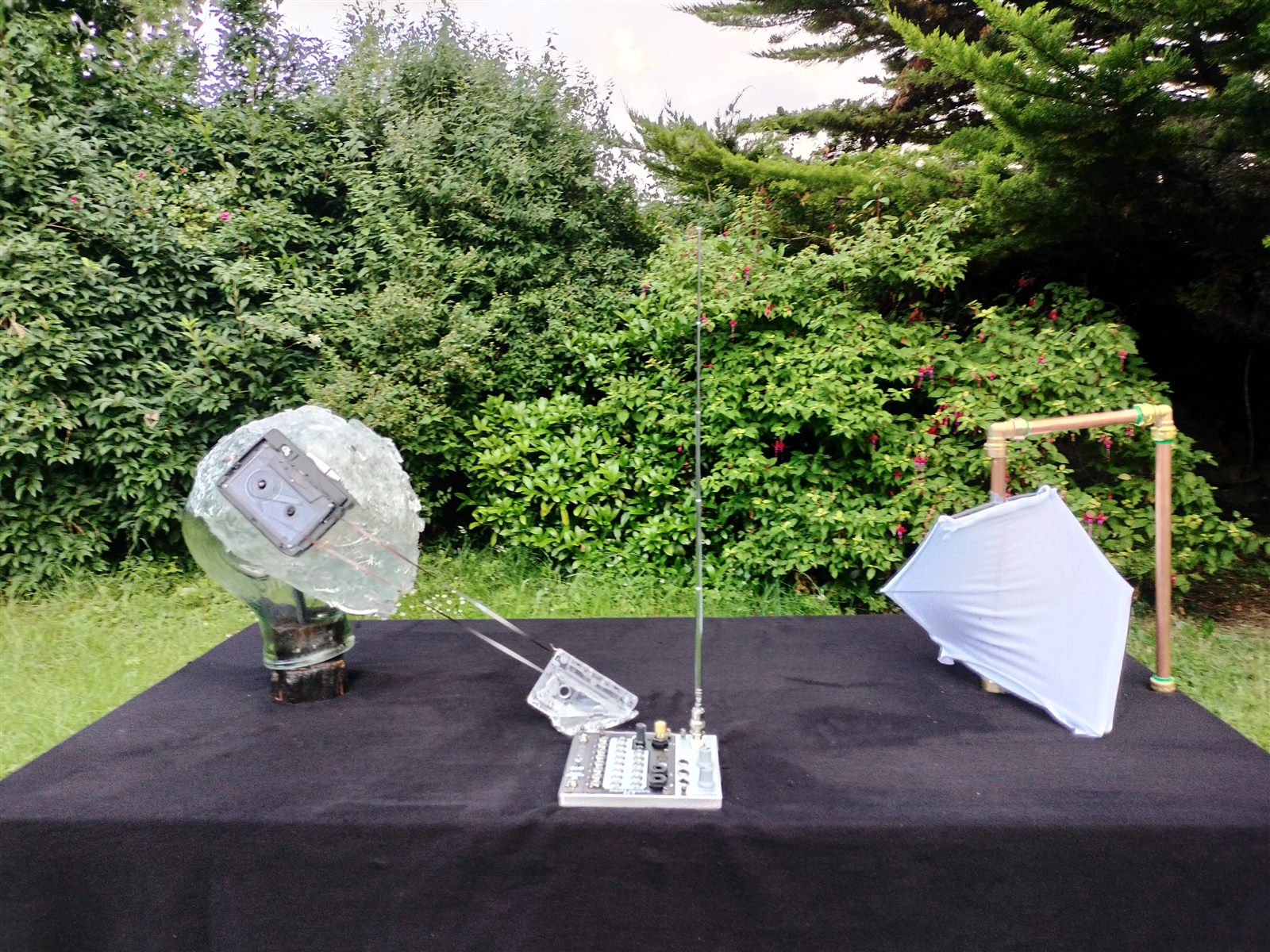 Oscillation — kinetic sculpture installed outdoors on a black-draped table