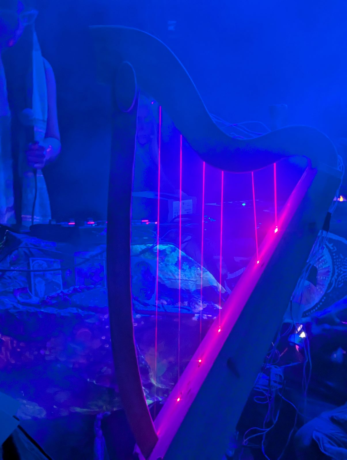 The laser harp glowing through blue haze during a live performance