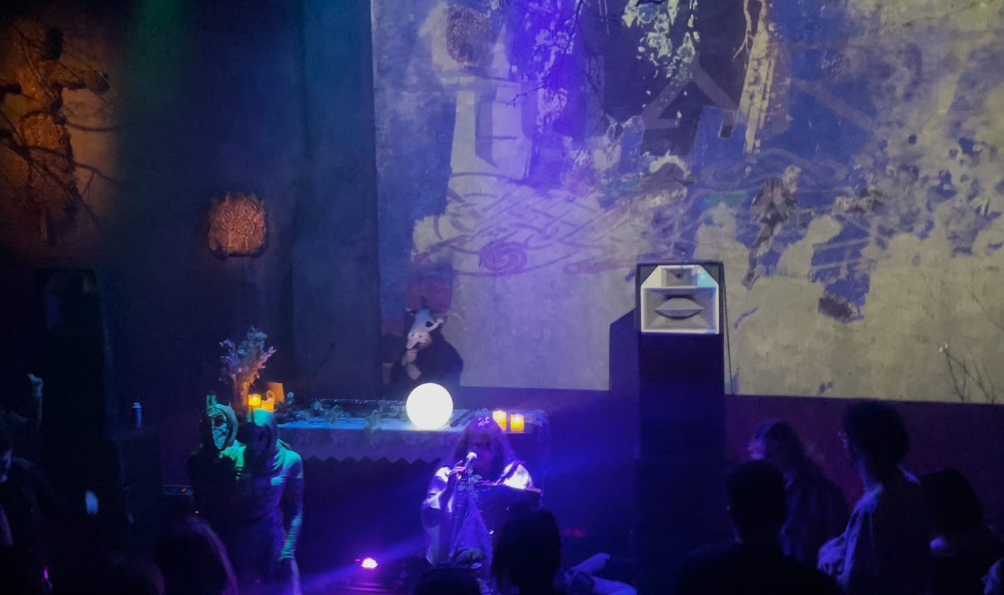 Projected visuals above a candle-lit stage during a live VJ set